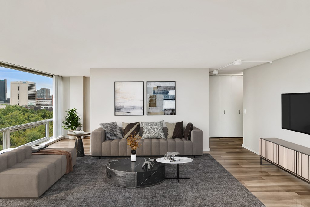 a living room with white walls and a large window with a city view at The Pavilion, Detroit, MI, 48207