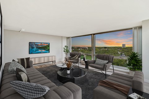 a living room with couches and chairs and a large window with a view