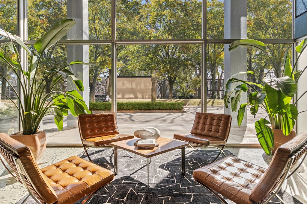 a living room with brown leather chairs and a table at The Pavilion, Detroit, 48207