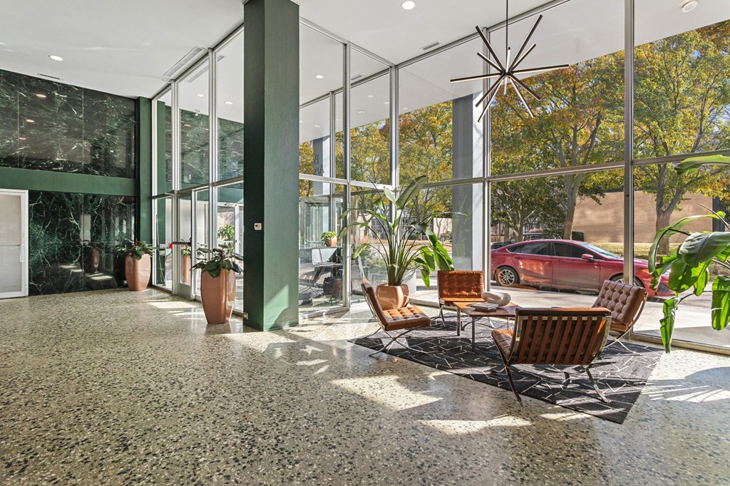 a lobby with a table and chairs and a red car in the window at The Pavilion, Detroit, Michigan