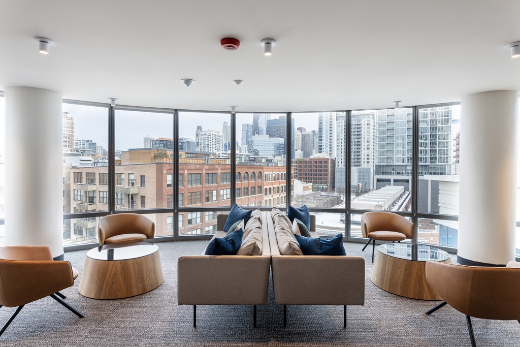 A modern living room with a view of the cityscape outside the large windows at Kingsbury Plaza, Chicago, IL