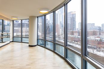 A large room with a view of the city through the windows. at Kingsbury Plaza Apartments, Chicago, IL