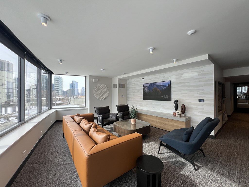 A modern living room with a brown leather couch and a blue chair at Kingsbury Plaza, Chicago, Illinois, 60654