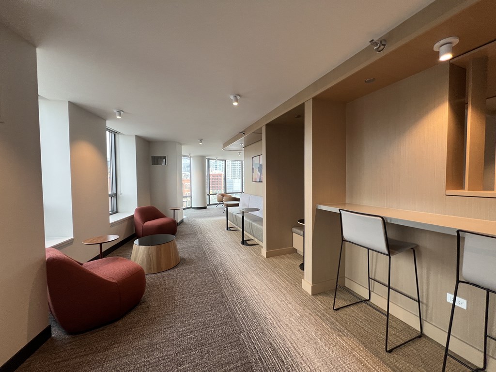 A long hallway with a row of chairs and a desk at Kingsbury Plaza, Chicago