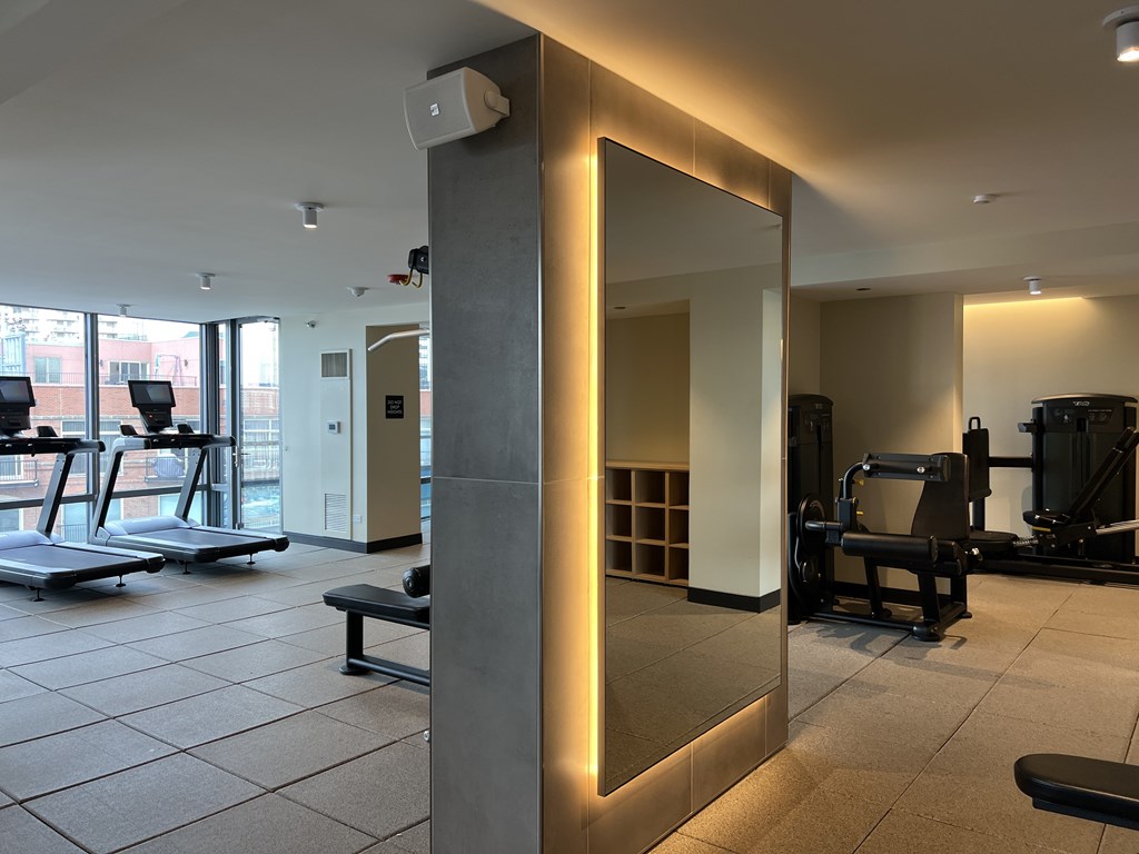 A gym with treadmills, weights and a mirror at Kingsbury Plaza, Chicago, Illinois