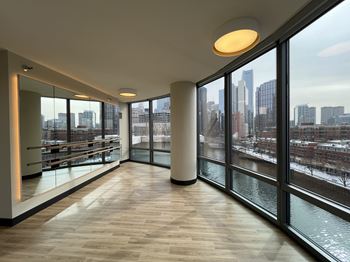 A long hallway with a view of the city outside the windows at Kingsbury Plaza Apartments, Chicago, Illinois
