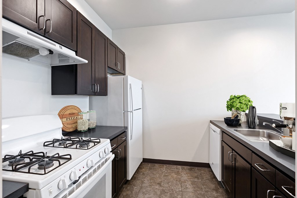 a kitchen with white appliances and black and white cabinets and a white refrigerator