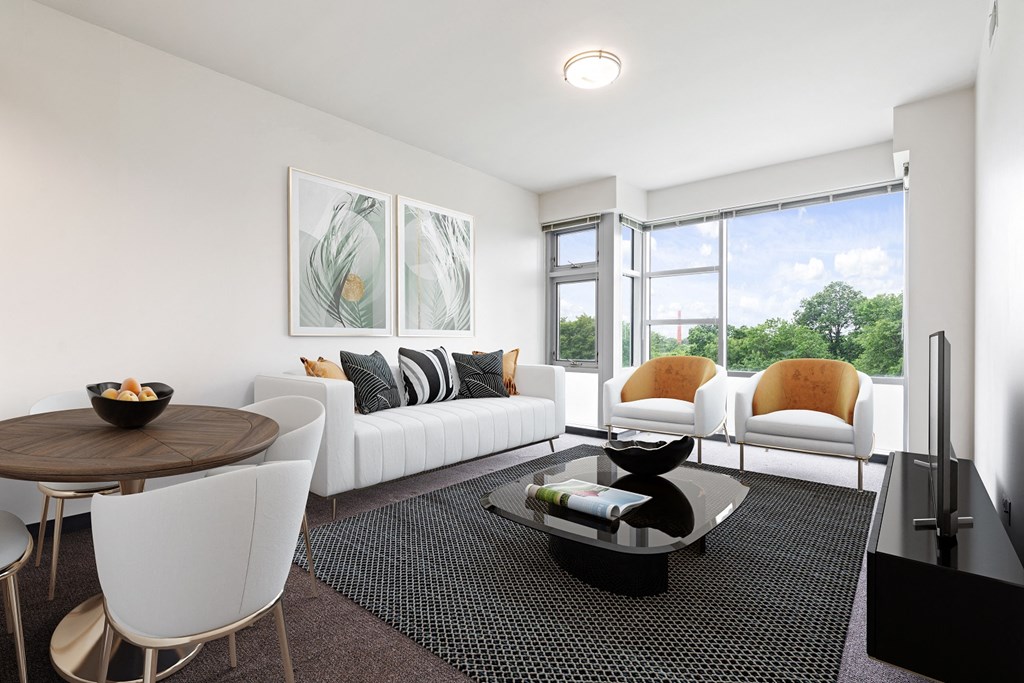 a living room with white furniture and a large window