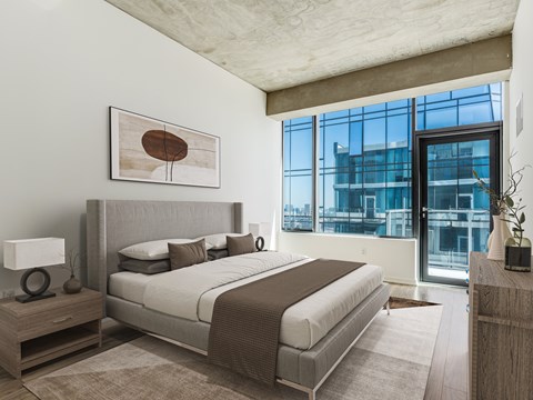 A bedroom with a large bed and a large window.
