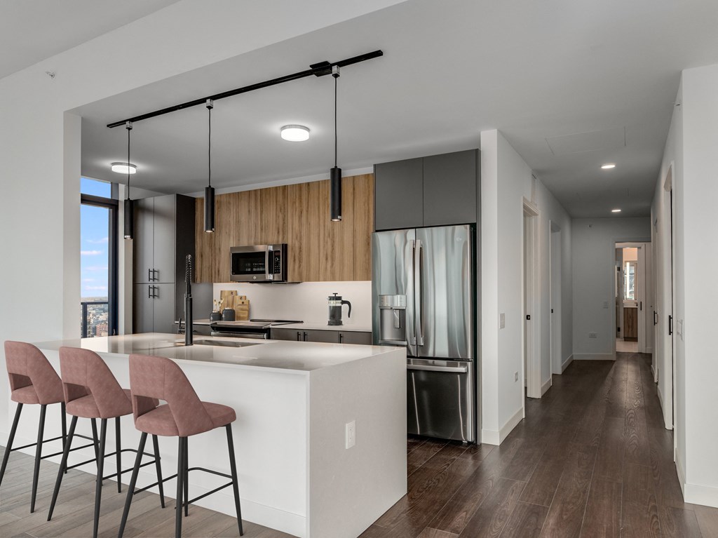 a kitchen with a large island with bar stools and a refrigerator at Cassidy on Canal, Illinois, 60606