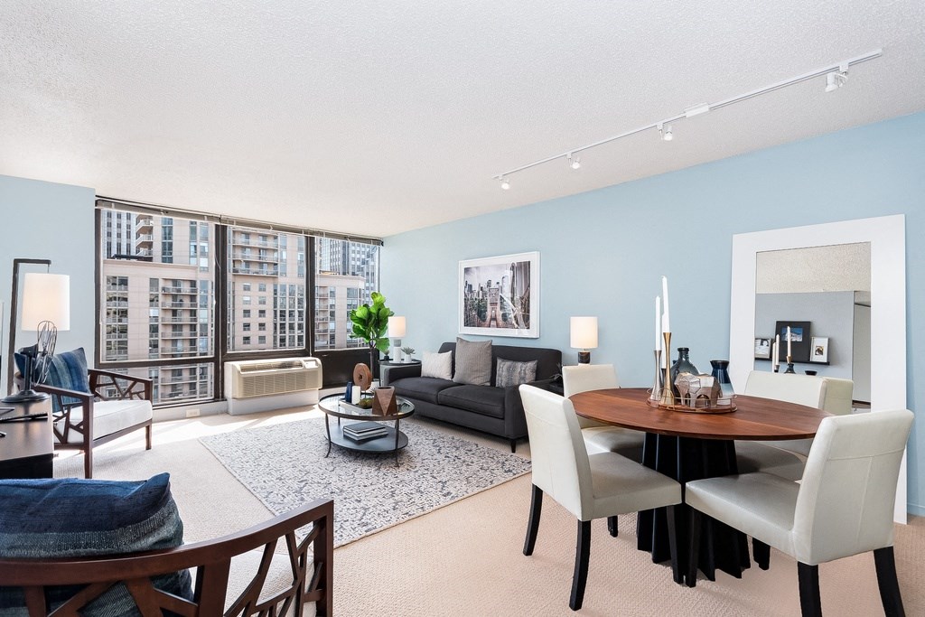 a living and dining room area with blue walls and a large window at Columbus Plaza, Illinois