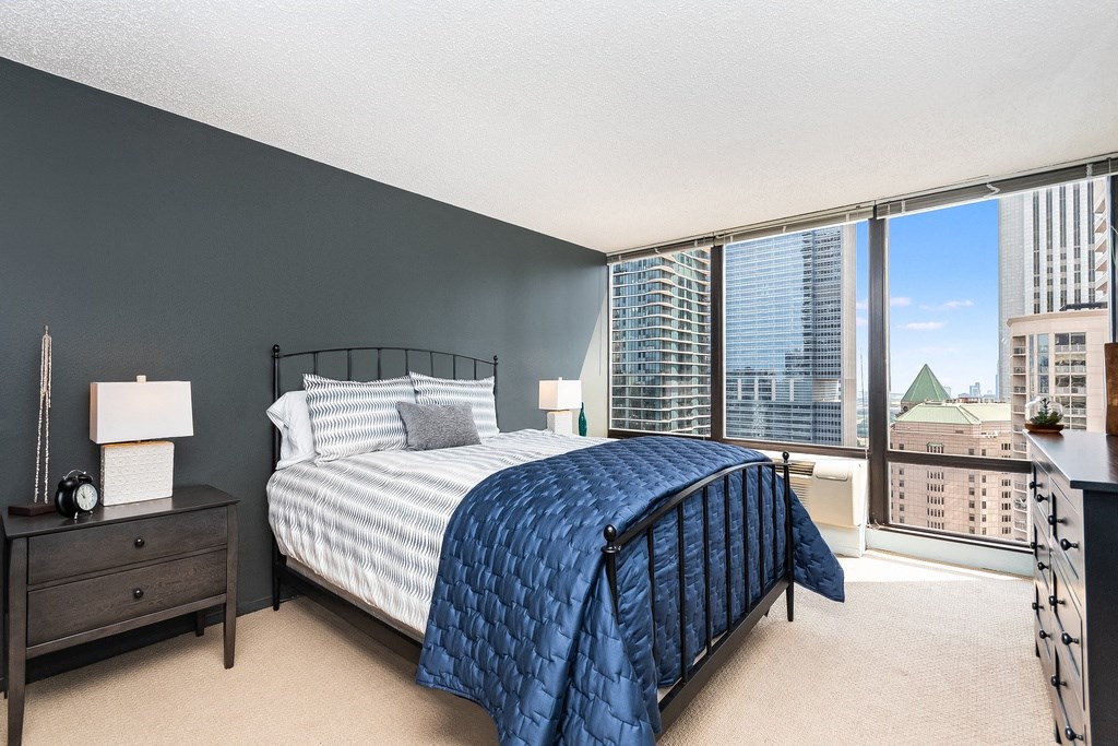 a bedroom with a large bed and a large window at Columbus Plaza, Chicago, IL