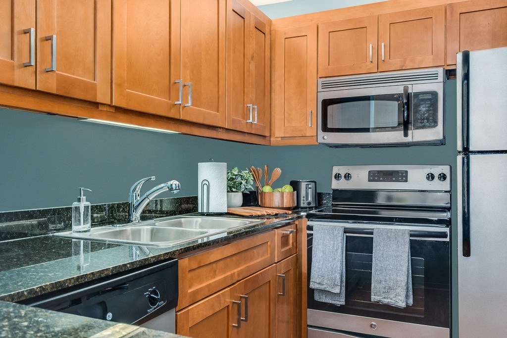 a kitchen with wood cabinets and stainless steel appliances at Columbus Plaza, Chicago, IL