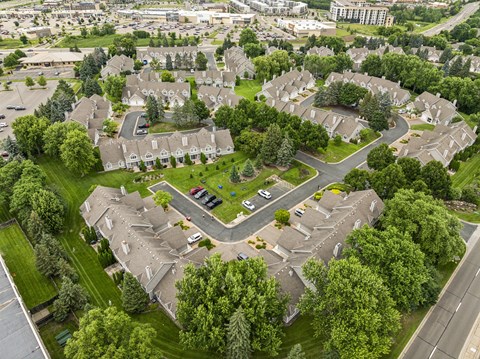 A bird's eye view of a residential area with houses and a central park at Seasons Villas Apartments, Woodbury 55125