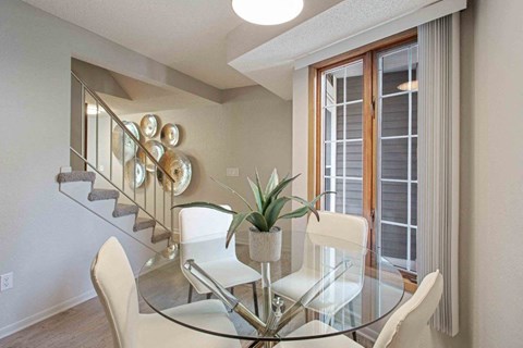 a dining room with a glass table and chairs at Seasons Villas, Woodbury Minnesota