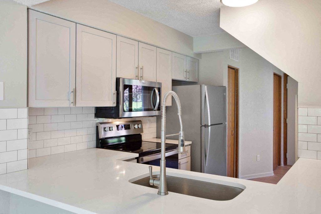 a kitchen with a sink and a refrigerator a kitchen with a sink and a refrigerator at Seasons Villas, Woodbury