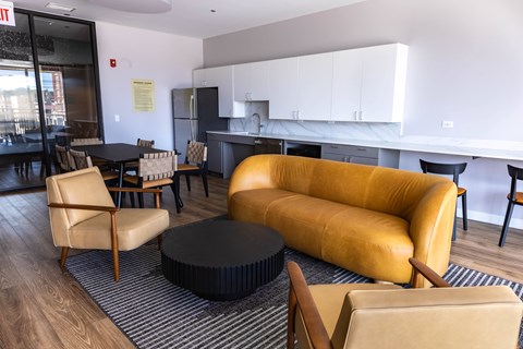 A yellow sofa sits in a living room with a black coffee table in front of it.