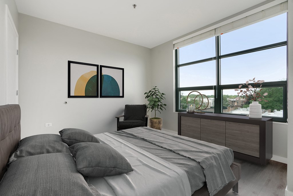 a bedroom with a bed and a large window