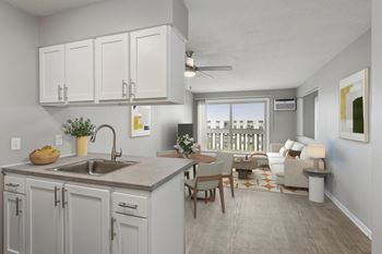 A kitchen with a sink, cabinets, and a dining table.