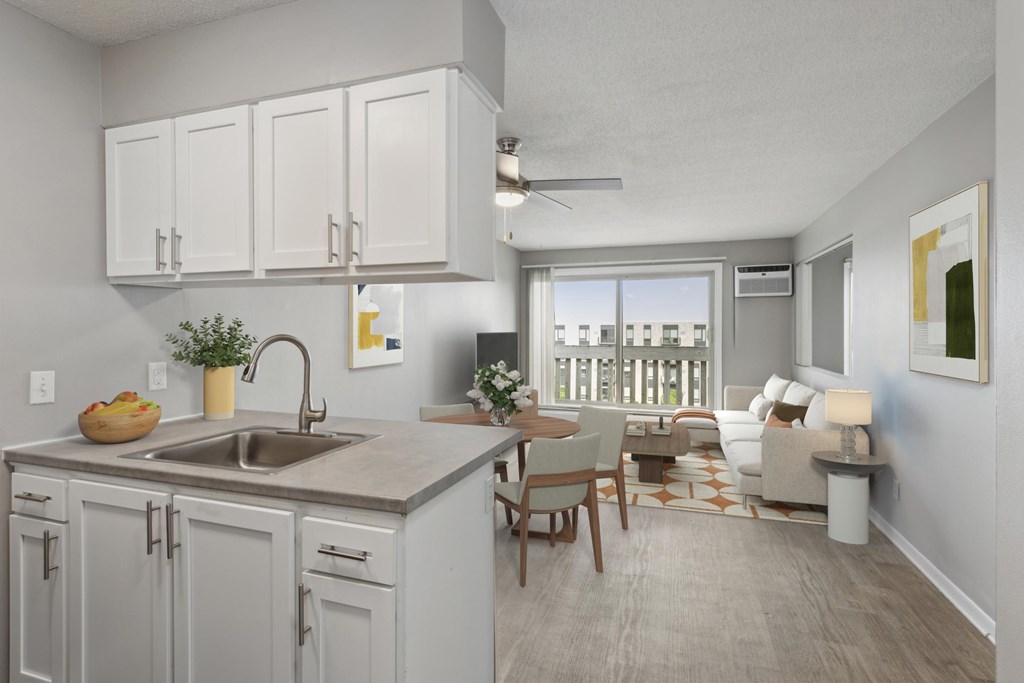 A kitchen with a sink, cabinets, and a dining table.