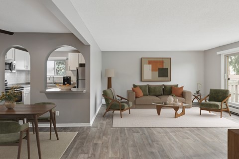 A living room with a grey couch, a wooden coffee table, and a painting on the wall.