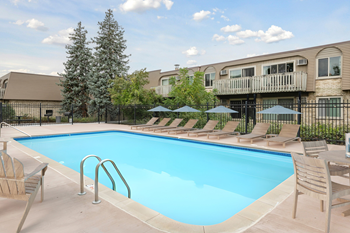 A swimming pool surrounded by chairs and umbrellas.