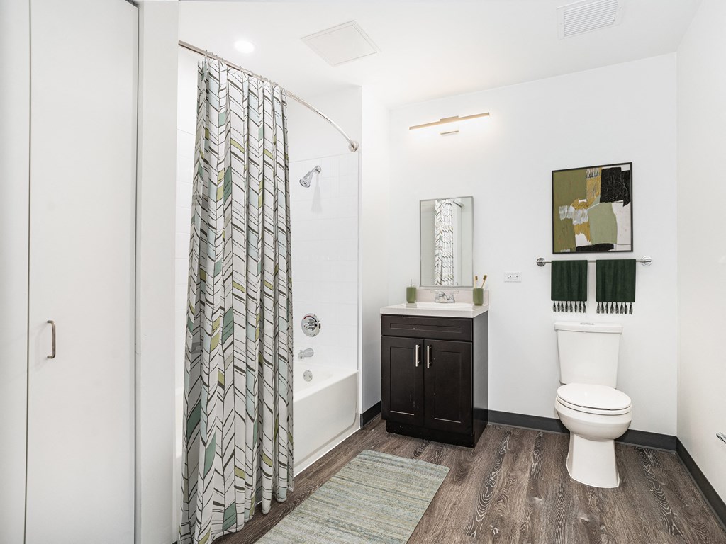 a bathroom with a shower and a toilet and a sink