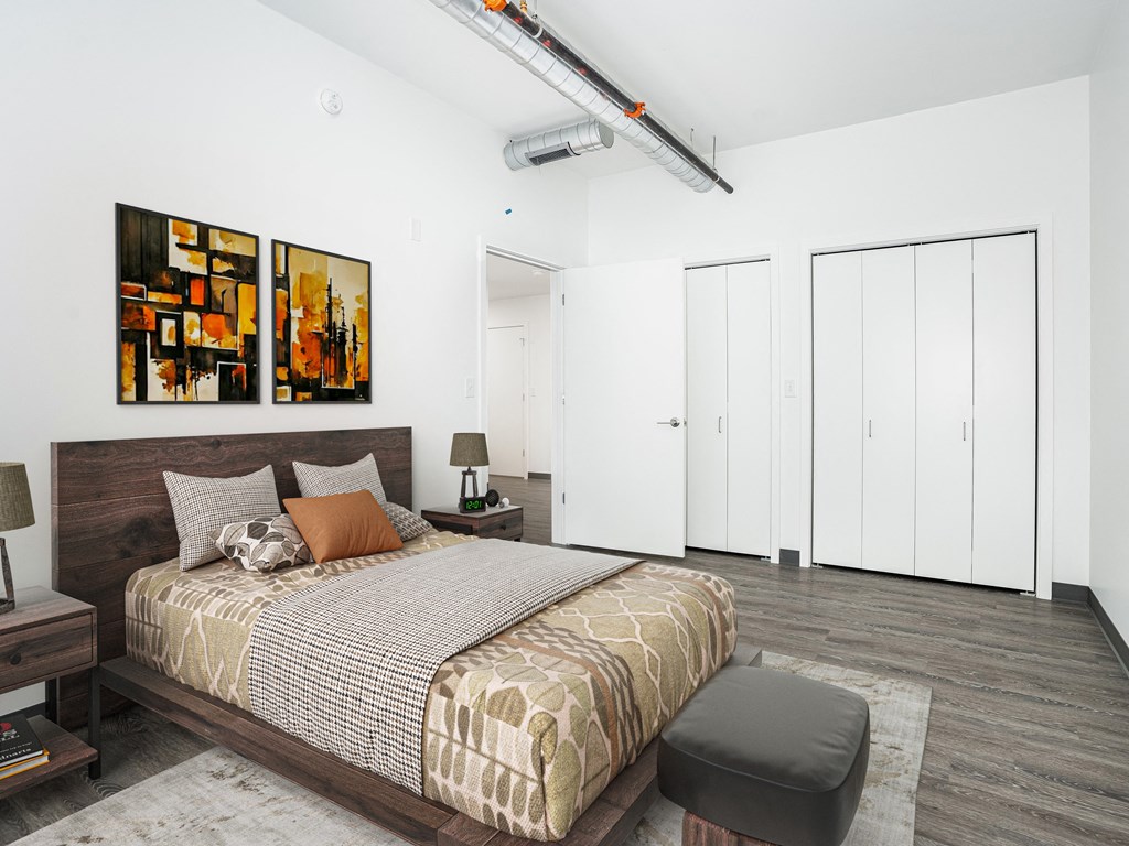 a bedroom with a bed and two paintings on the wall