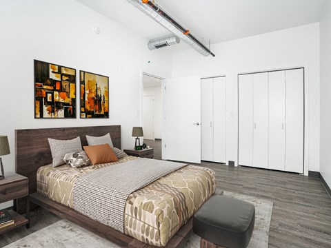 a bedroom with a bed and two paintings on the wall