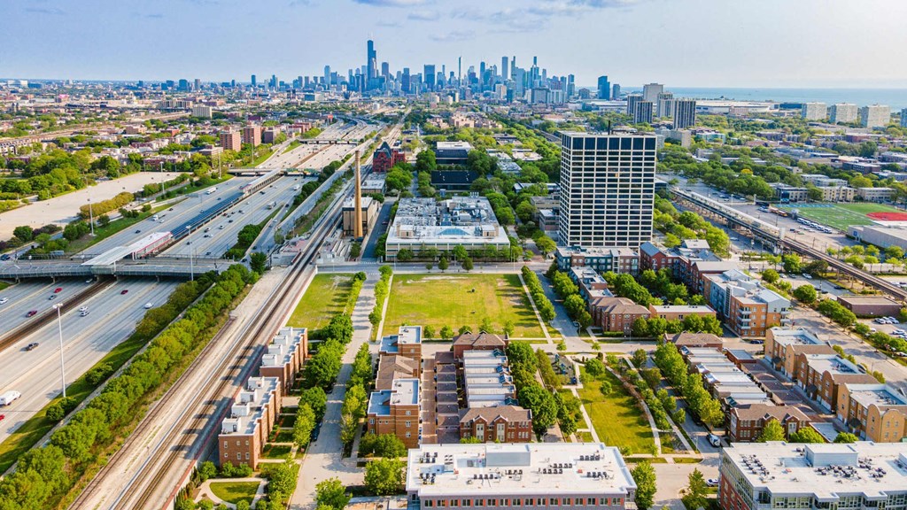 A cityscape with a highway and buildings in the foreground.