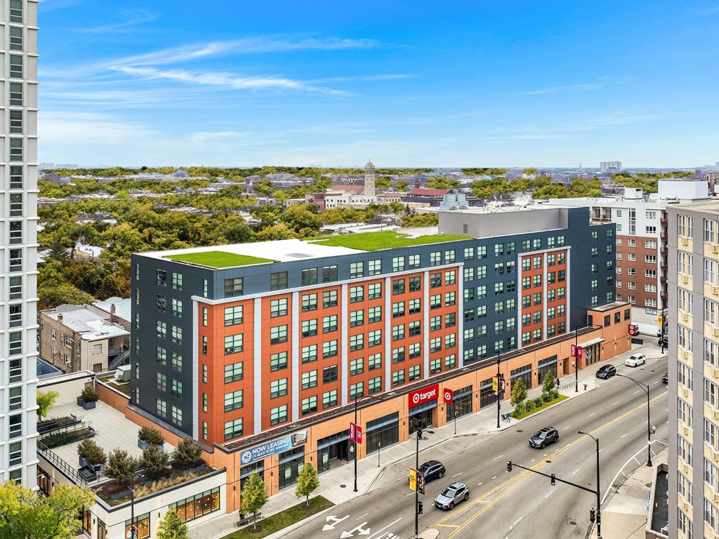 a large building with a green roof on a city street