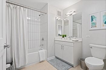a white bathroom with a shower toilet and sink