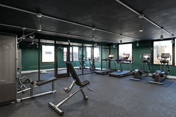a large fitness room with treadmills and other exercise equipment