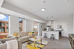 a living room filled with furniture and a kitchen