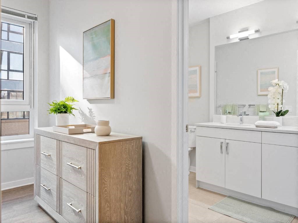 A bathroom with a wooden cabinet and a mirror.