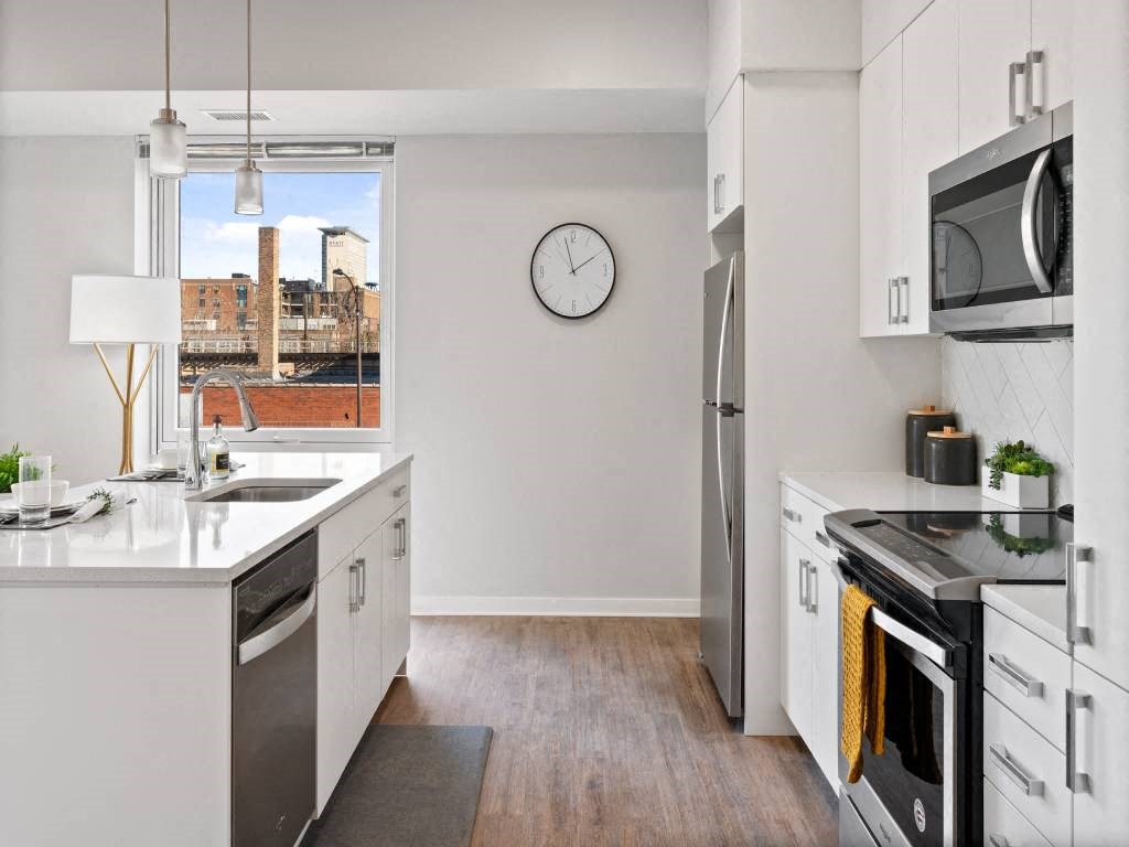 A modern kitchen with white cabinets and stainless steel appliances.