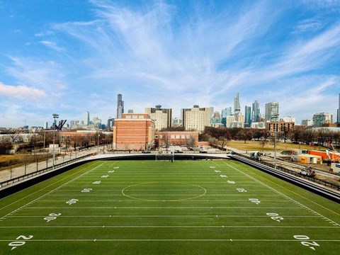 A football field with numbers on it and a city skyline in the background.