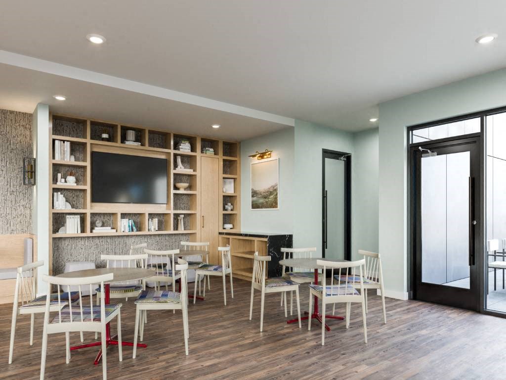 A modern dining room with a wooden floor and white chairs.
