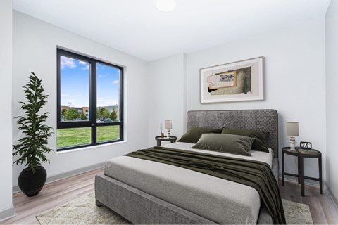 A bedroom with a large bed and a view of the outdoors through a window.