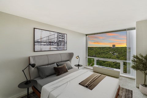 A bedroom with a large bed and a picture on the wall.