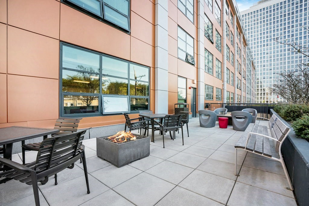 an outdoor patio with tables and chairs and a fire pit at Concord at Sheridan