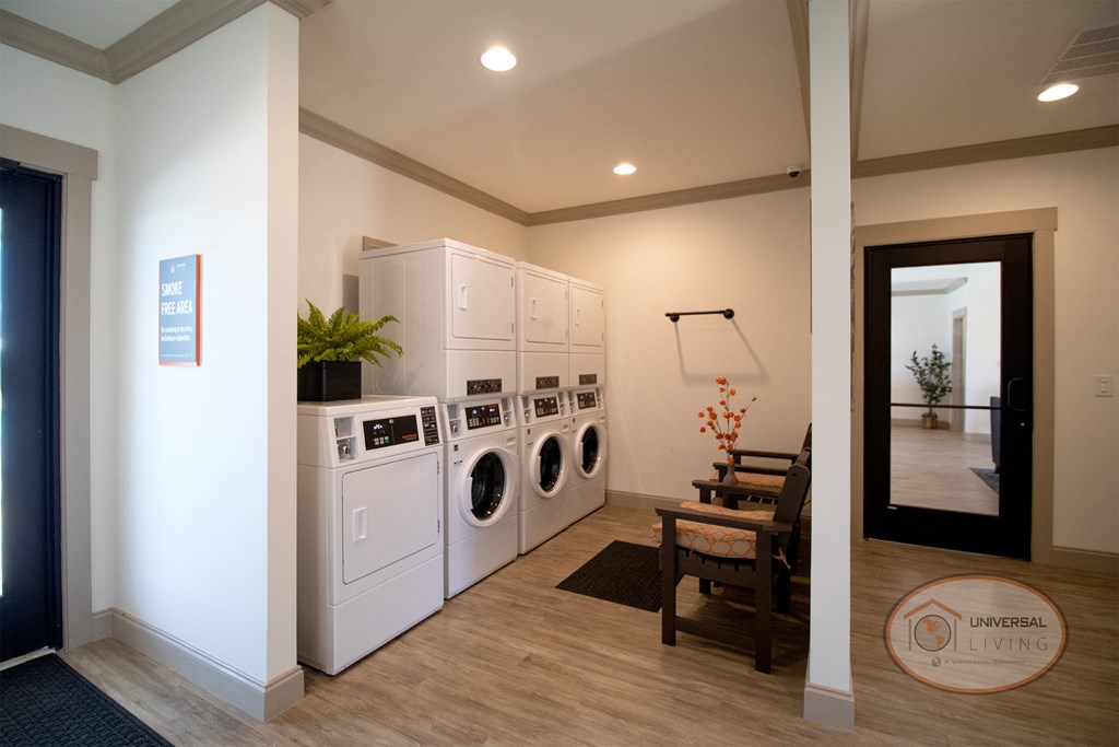 A laundry center with washers, dryers, and seating.