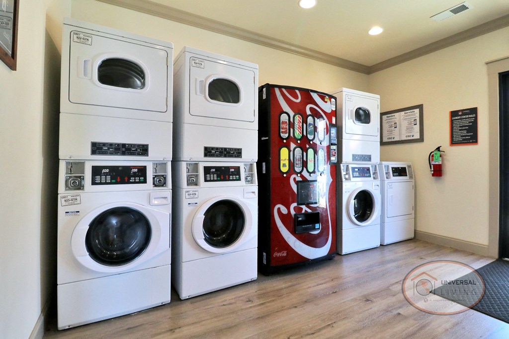 a laundry room with a row of washing machines and a coca cola refrigerator