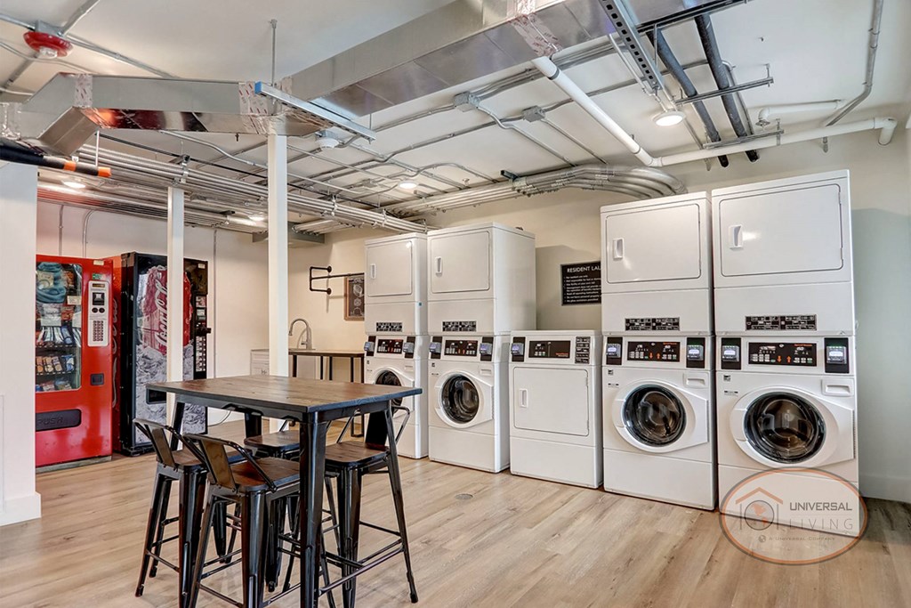 a laundry room with washing machines and a table with chairs