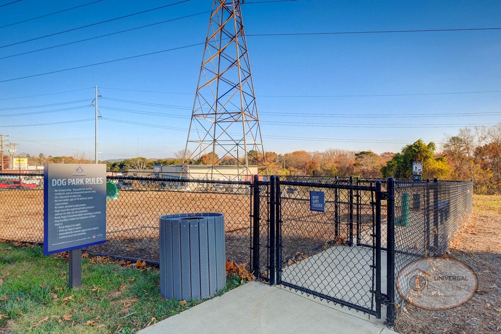 A dog park with seating, water station for pets, pet water pick-up station, and obstacles for your dog to play on.