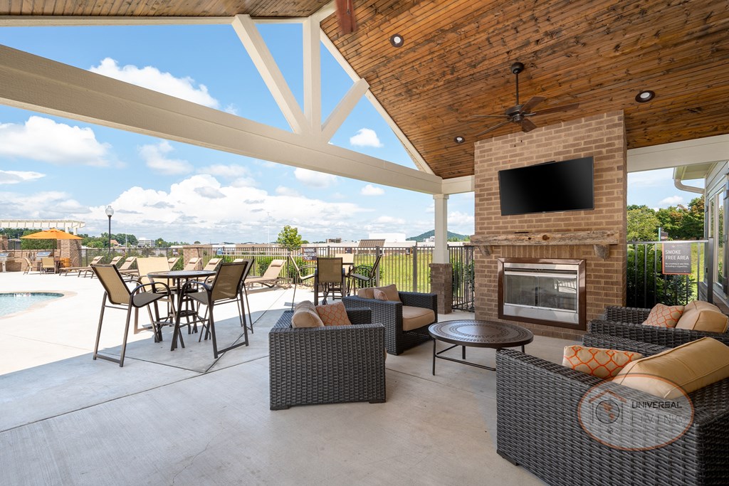 a covered patio with furniture and a fireplace