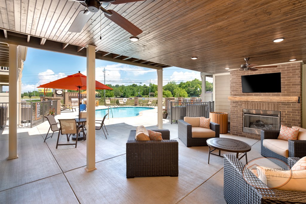 Poolside patio with flat screen TV, fireplace, ceiling fans, and lounge seating