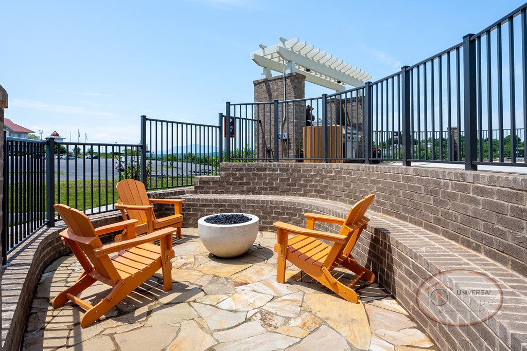 a patio with orange chairs and a fire pit