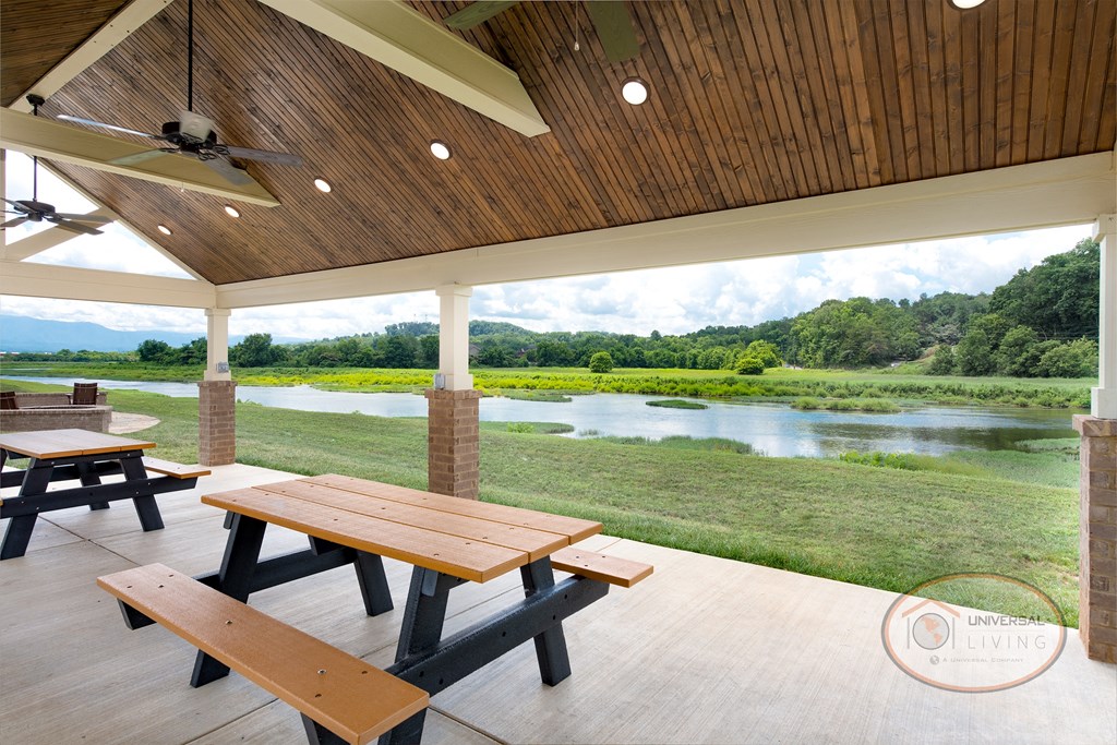A covered picnic area with tables, ceiling fans, and a view of  the river.