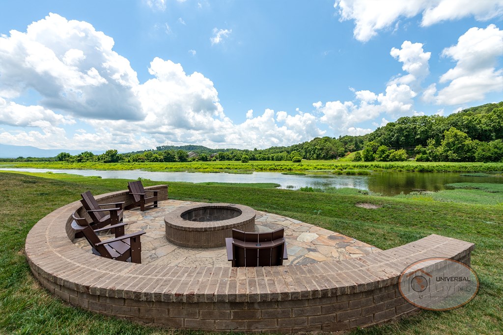 A brick fire pit with seating overlooking stunning mountain views.